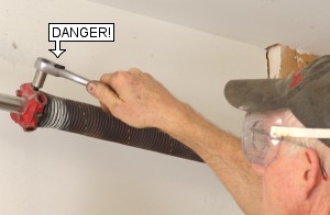 Maintenance workers and DIY homeowners: Precautions and safety warnings before unwinding garage door torsion springs.