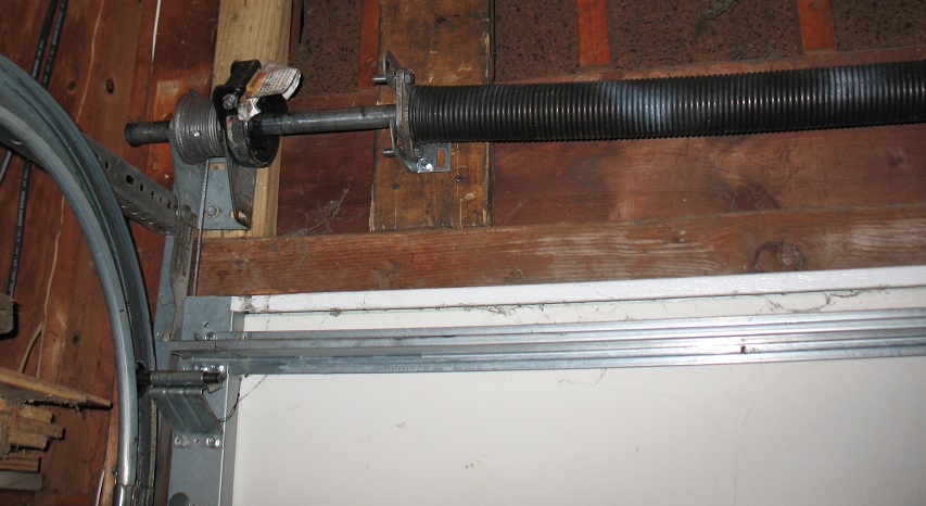 Standard torsion spring with spring anchor bracket on a garage door