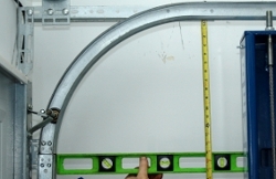 Hold a level at the bottom of the track junction, and measure the distance from the bottom of the horizontal track to the top of the level.