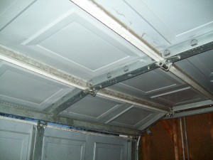 A view of a garage door buckling, this can be corrected in the spring.