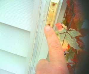 A person's hand attempting to ring a old fashion door bell pertaining to the launch of DDM's garage door parts page.