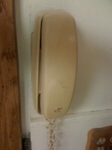 An image of an older wall mounted phone that can be used to contact DDM about replacing your garage door springs. 