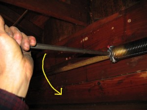 A professional winding a torsion spring.