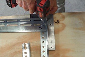 A professional using an impact wrench to assemble a high lift track.