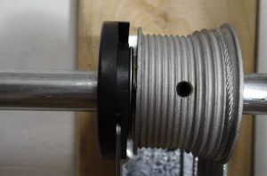 An image showing the correct installation of the black plastic bearing holder with the bearing next to the cable drum prohibiting it from coming out.