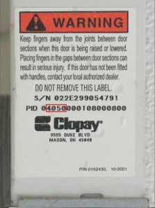 A warning sticker on a garage door with the model number 4050 circled in red.