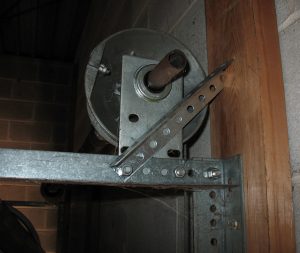 An angle that is bolted to the horizontal angle and wedges against the jamb to support the end bearing plate.