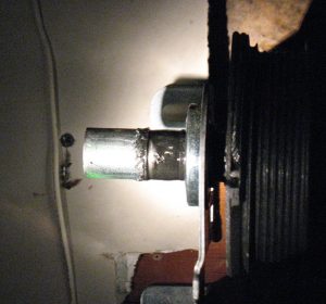 A view of a garage door shaft that is worn.