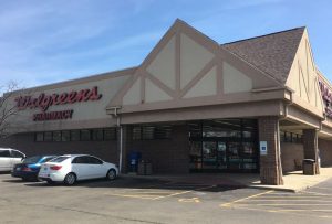 A picture of a Walgreens store with cars parked in front.