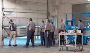 Dan Musick is training maintenance personnel to replace a bottom garage door section.