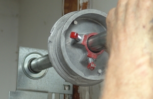 Pushing the shaft so that the cable drum is adjacent to the end bearing