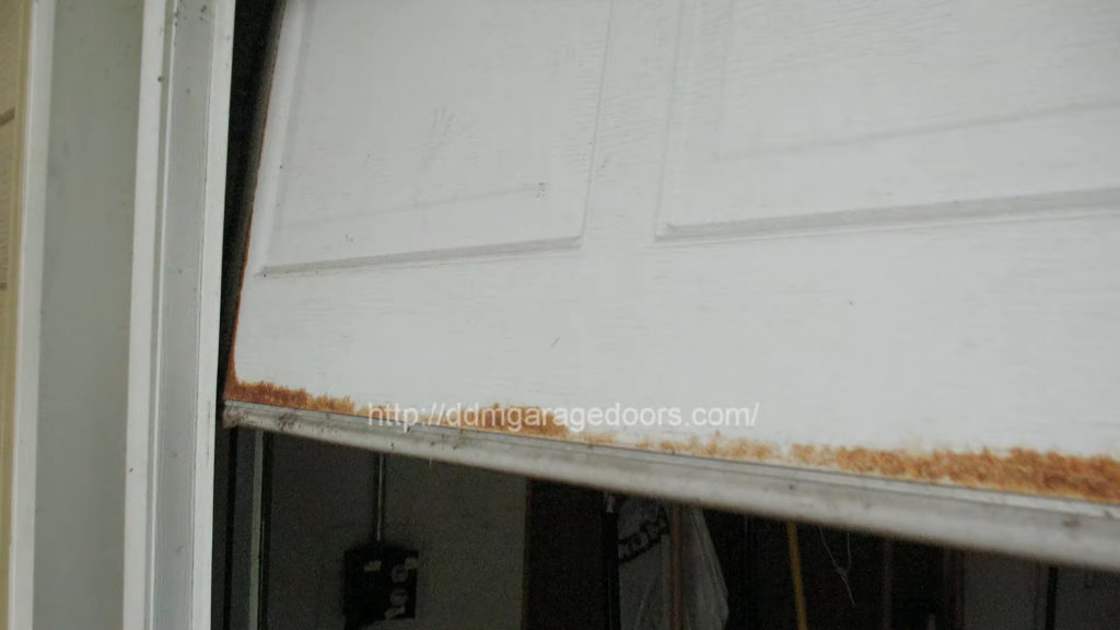 A white-painted door with water damage along the bottom. Covering a door like this with a C-channel seal or retainer will make the door last longer