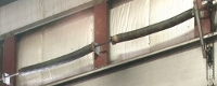 Linear System: Two springs installed on the left side of this garage door, with two other springs on the right side as well.