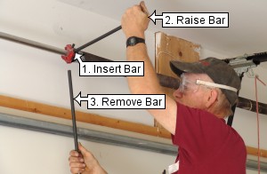 Insert second bar to unwind garage door torsion springs.